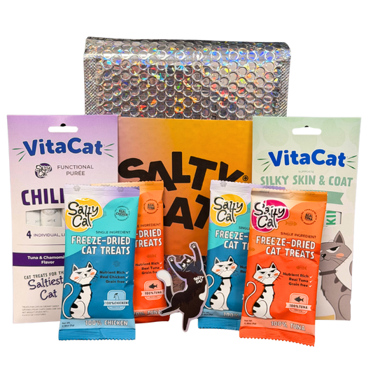 Salty Cat Goodie Bag and VitaCat treats by a shiny, textured bag.